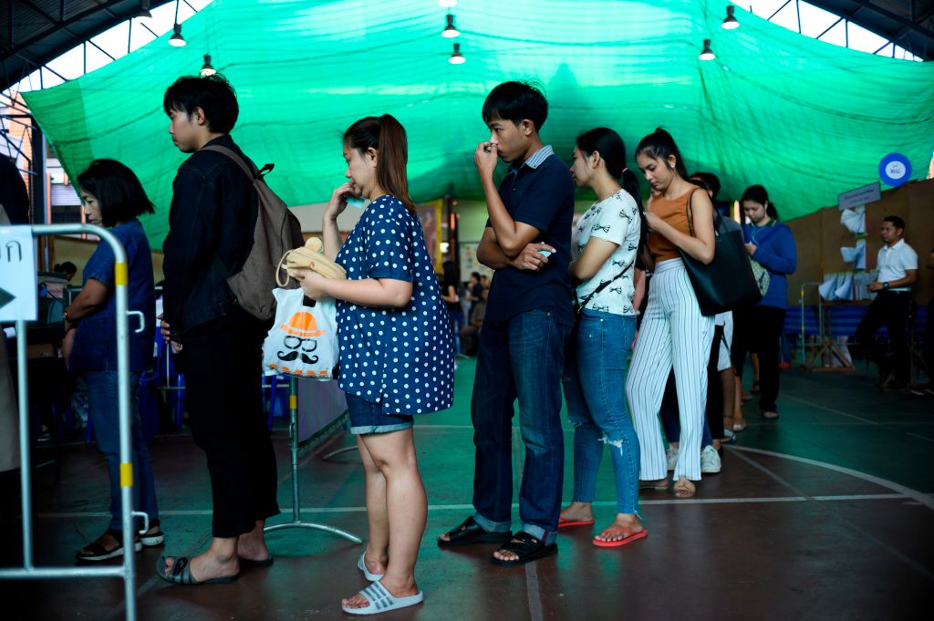 People queue to cast their ballots during early voting in Bangkok