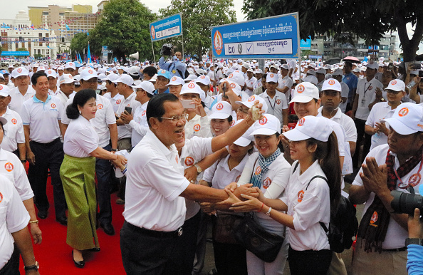 Prime Minister and President of Cambodian People's Party Hun Sen shakes hands  ahead of the rally.