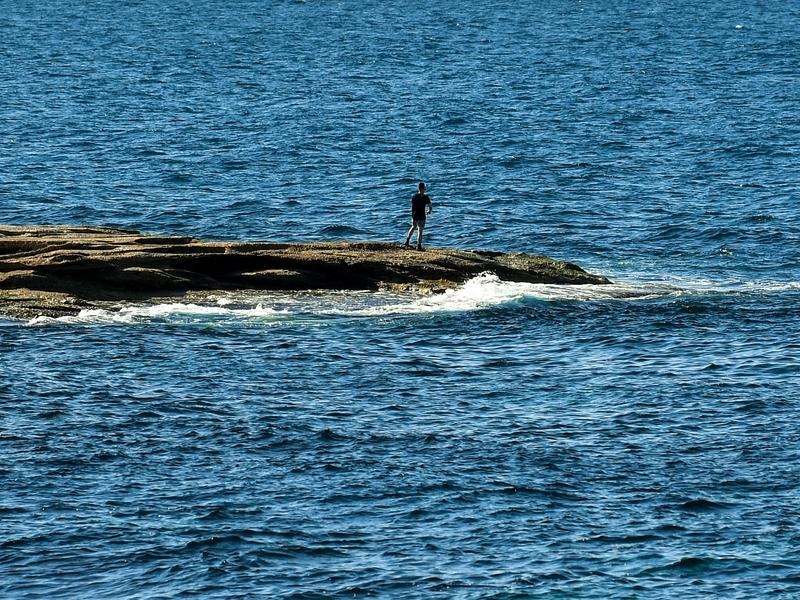 A fisherman is seen fishing at Coogee