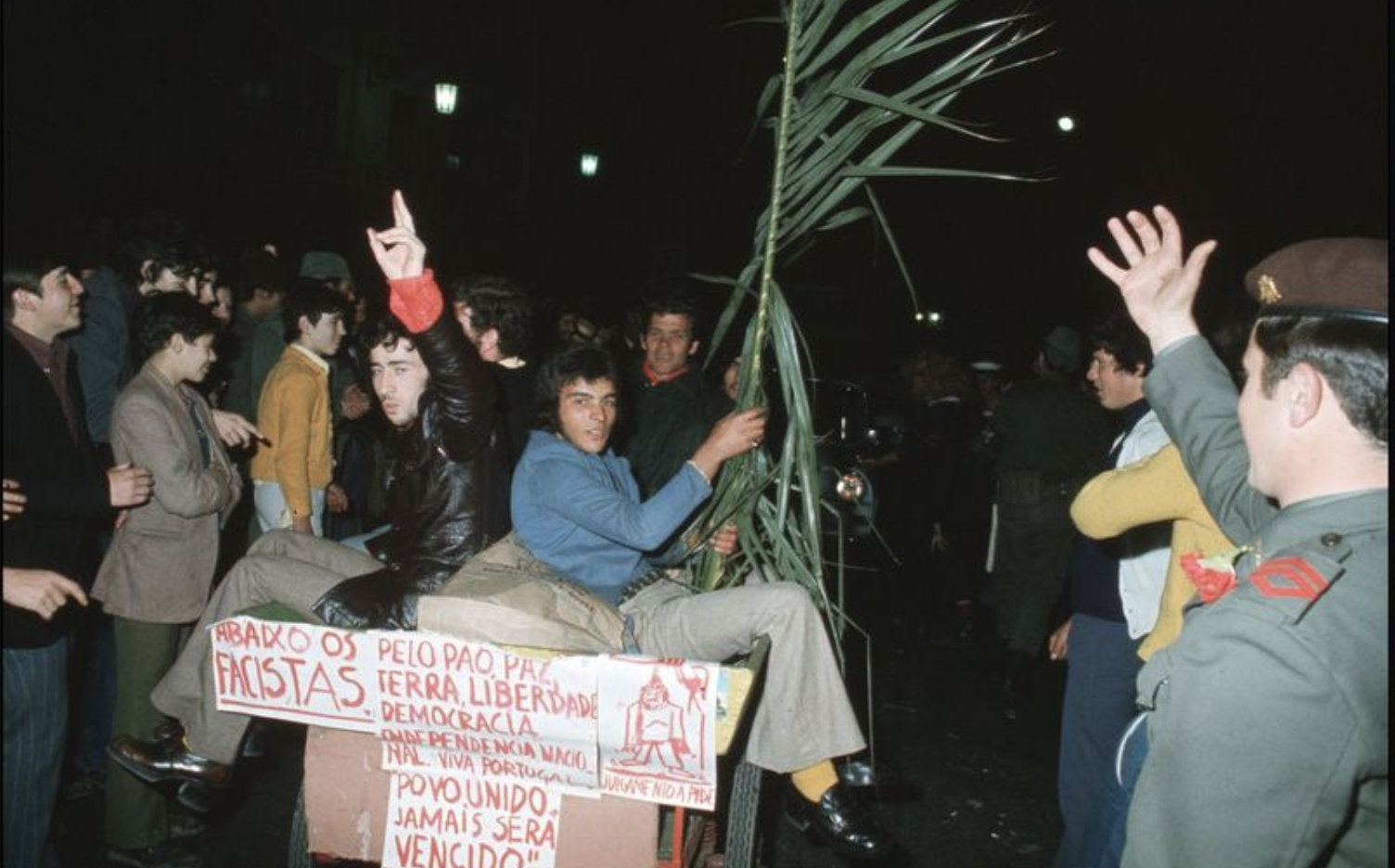 Povo comemora com os militares a rendição do governo ditatorial como consequência da Revolução dos Cravos